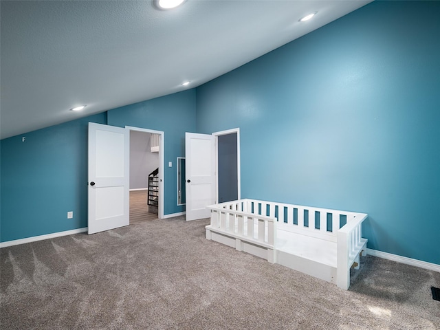 unfurnished bedroom with baseboards, lofted ceiling, and carpet floors