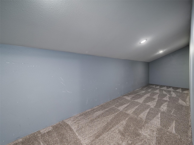 carpeted spare room featuring recessed lighting and vaulted ceiling