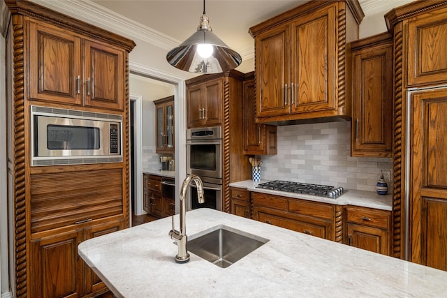 kitchen featuring a sink, stainless steel appliances, decorative backsplash, light stone counters, and hanging light fixtures