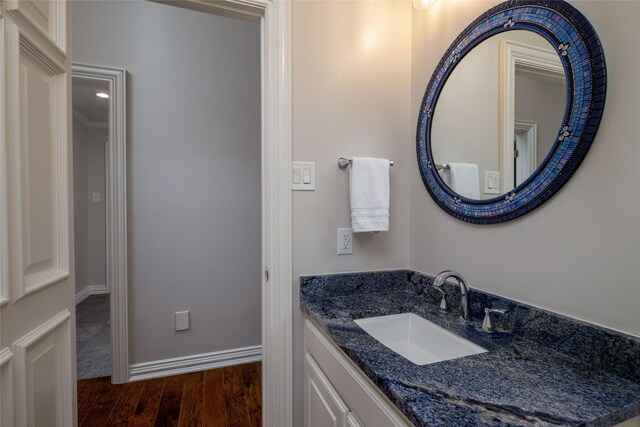 bathroom with vanity, wood finished floors, and baseboards