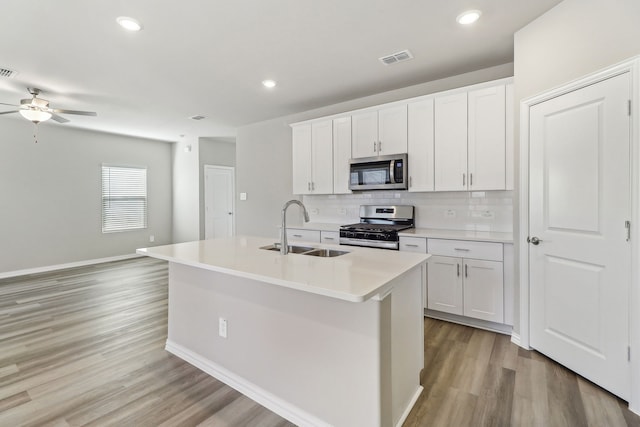 kitchen featuring a sink, light wood-style floors, ceiling fan, visible vents, and appliances with stainless steel finishes