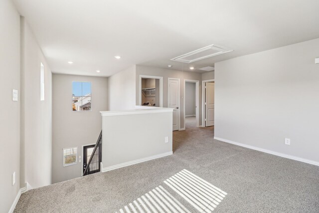 carpeted empty room featuring attic access, visible vents, recessed lighting, and baseboards