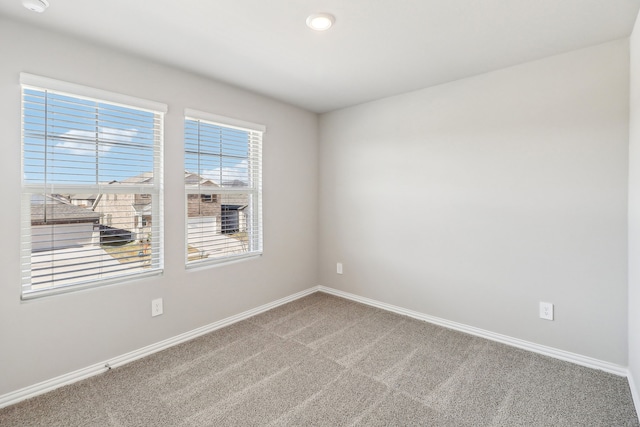carpeted empty room with baseboards