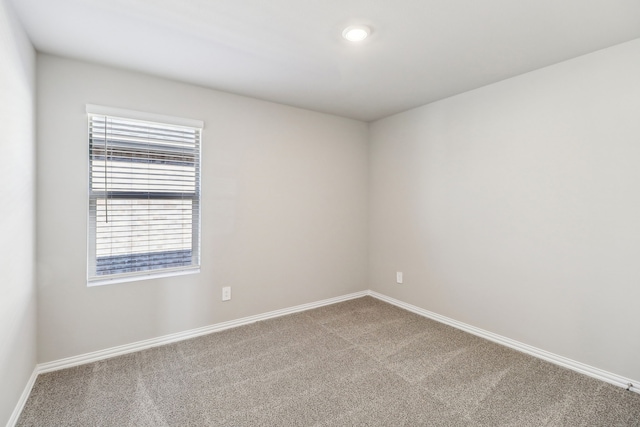 carpeted empty room featuring baseboards