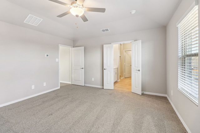 unfurnished bedroom with visible vents, ceiling fan, light carpet, and baseboards