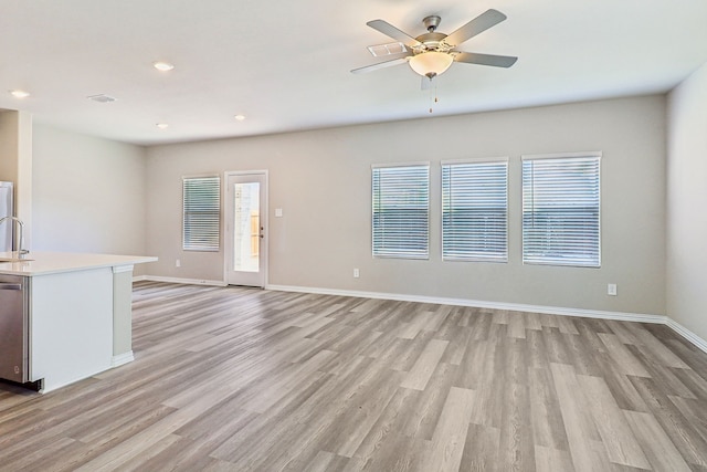 unfurnished living room featuring ceiling fan, recessed lighting, light wood finished floors, and baseboards