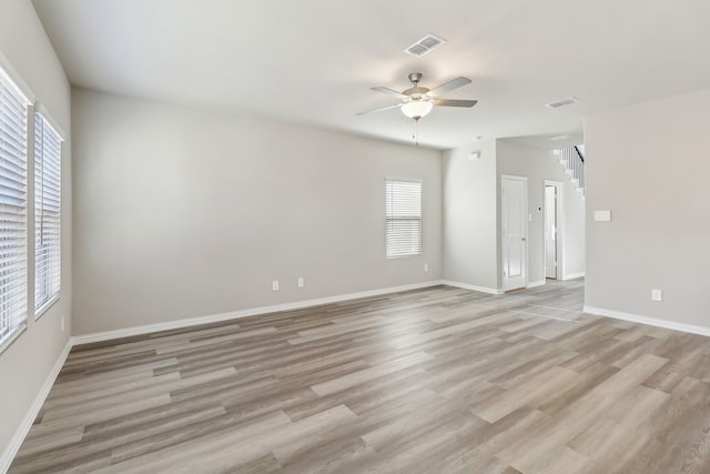 unfurnished room featuring light wood finished floors, visible vents, ceiling fan, and a healthy amount of sunlight