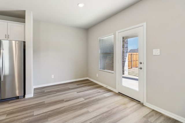 unfurnished dining area with light wood finished floors and baseboards
