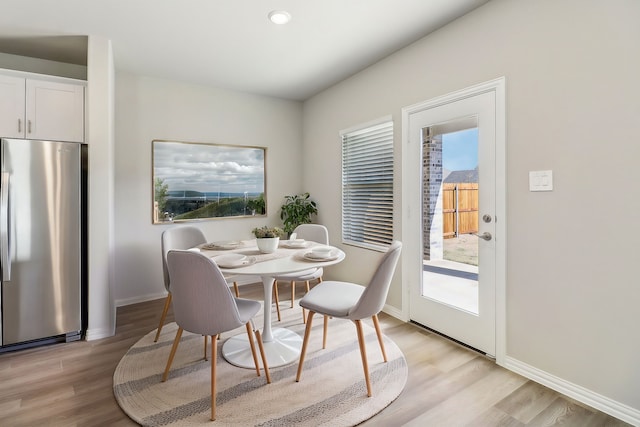 dining area with light wood-style flooring and baseboards