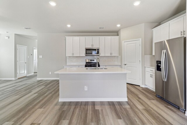 kitchen with visible vents, stainless steel appliances, light wood-type flooring, and a sink