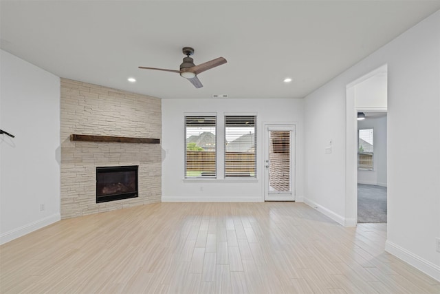 7416 San Jacinto Trl, Mckinney, TX 75071 - unfurnished living room featuring a ceiling fan, plenty of natural light, a stone fireplace, wood finished floors, and recessed lighting