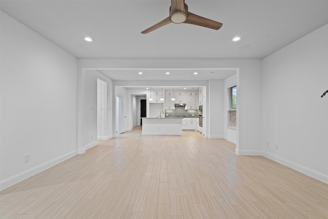 7416 San Jacinto Trl, Mckinney, TX 75071 - unfurnished living room with a ceiling fan, recessed lighting, baseboards, a sink, and light wood-type flooring