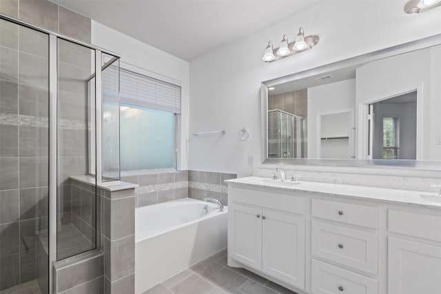 bathroom featuring a sink, a bath, a stall shower, double vanity, and tile patterned flooring