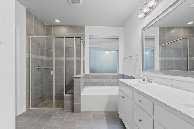 full bathroom with a shower stall, vanity, tile patterned floors, visible vents, and a garden tub
