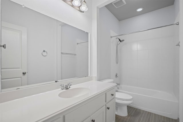 bathroom featuring visible vents, toilet, shower / washtub combination, and vanity