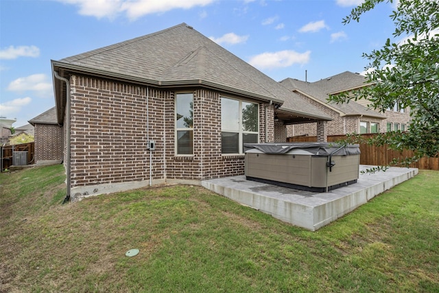 7416 San Jacinto Trl, Mckinney, TX 75071 - rear view of house featuring a hot tub, brick siding, roof with shingles, and central AC