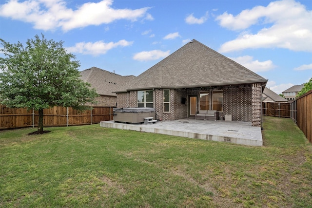 rear view of property with a fenced backyard, brick siding, a hot tub, roof with shingles, and a patio area
