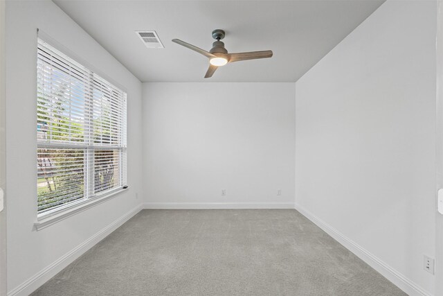 spare room featuring baseboards, visible vents, a ceiling fan, and carpet