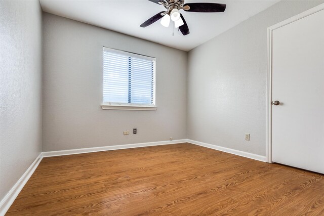unfurnished room featuring baseboards, wood finished floors, and ceiling fan