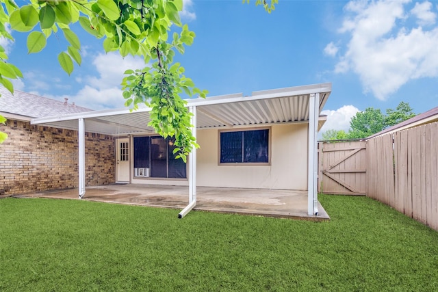 rear view of house featuring a patio, fence, a gate, and a lawn