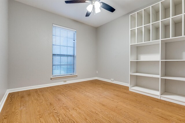unfurnished room featuring ceiling fan, wood finished floors, and baseboards