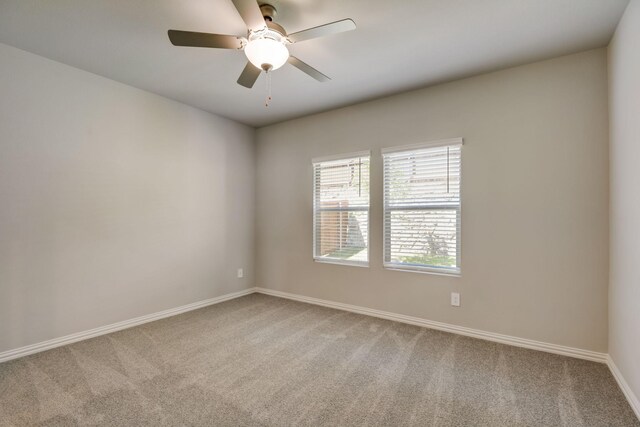unfurnished room with baseboards, a ceiling fan, and carpet