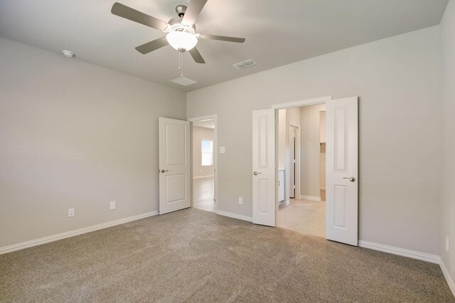 unfurnished bedroom with light colored carpet, visible vents, ceiling fan, and baseboards