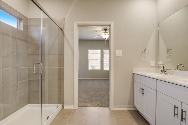 bathroom with a sink, ceiling fan, tile patterned floors, a stall shower, and double vanity