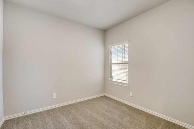 carpeted empty room with baseboards