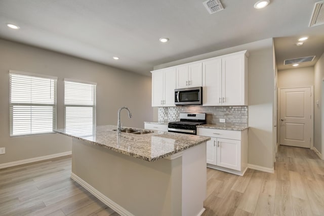 kitchen featuring tasteful backsplash, visible vents, appliances with stainless steel finishes, and a sink