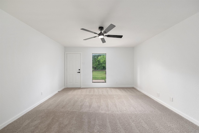 unfurnished room with a ceiling fan, light carpet, and baseboards