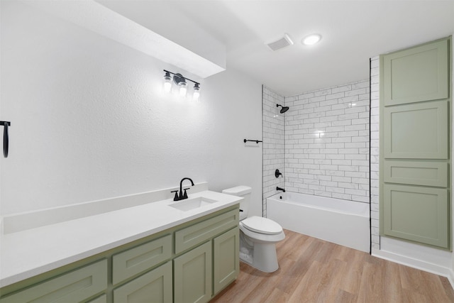 bathroom featuring wood finished floors, toilet, shower / bathtub combination, vanity, and visible vents