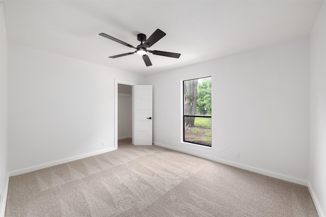 unfurnished bedroom featuring baseboards, a closet, and light colored carpet