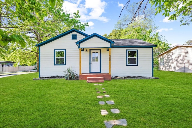 bungalow-style house with fence and a front lawn