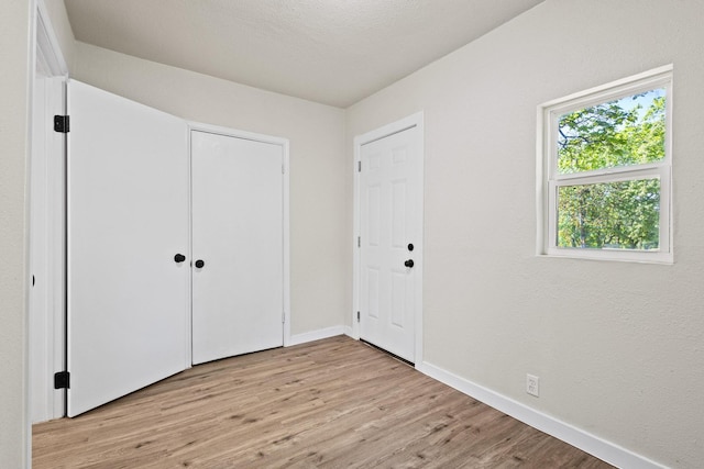 900 W Coffin St, Denison, TX 75020 - unfurnished bedroom with light wood-style floors, baseboards, and a closet