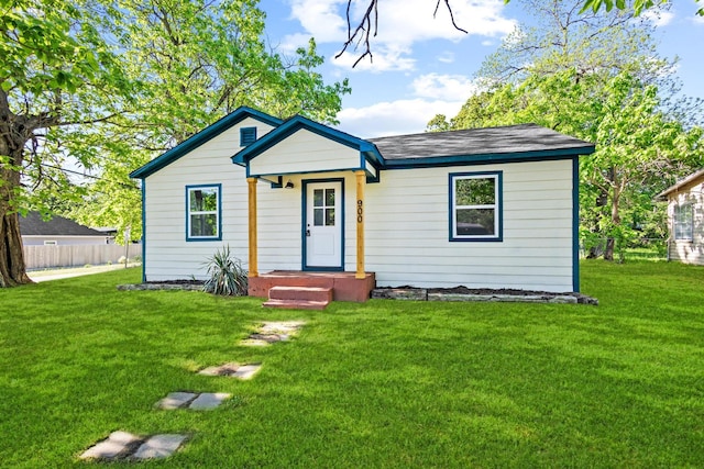 bungalow-style home featuring fence and a front lawn