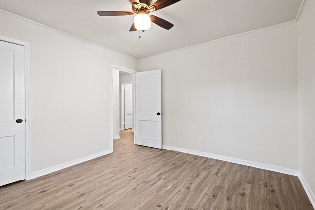 unfurnished bedroom with ornamental molding, a ceiling fan, light wood-style flooring, and baseboards