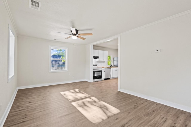 900 W Coffin St, Denison, TX 75020 - unfurnished living room with light wood-type flooring, ceiling fan, ornamental molding, baseboards, and a sink