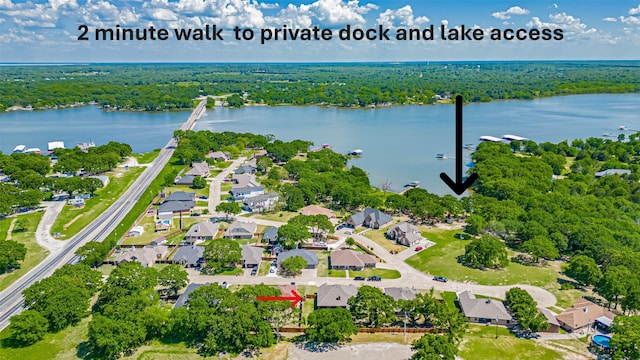 drone / aerial view with a residential view, a water view, and a view of trees