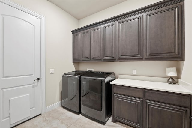laundry room featuring light tile patterned floors, cabinet space, independent washer and dryer, and baseboards