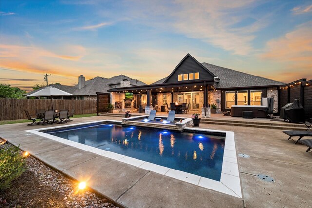 view of swimming pool with a patio area, a fenced in pool, a fenced backyard, a jacuzzi, and an outdoor hangout area