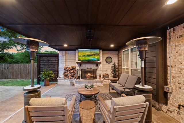 view of patio / terrace featuring fence and an outdoor living space with a fireplace