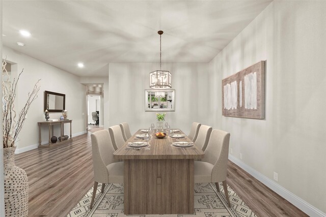 dining area with baseboards, recessed lighting, an inviting chandelier, and light wood finished floors