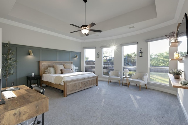 bedroom with carpet floors, a tray ceiling, and visible vents