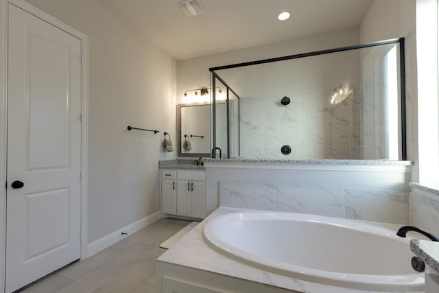 full bath featuring vanity, baseboards, a stall shower, and a bath
