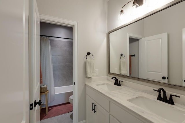 full bathroom featuring double vanity, a sink, tile patterned floors, and toilet