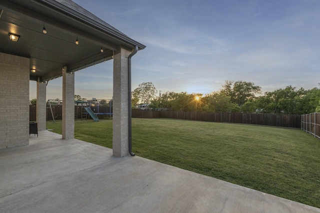 view of yard with a fenced backyard, a patio area, and a playground