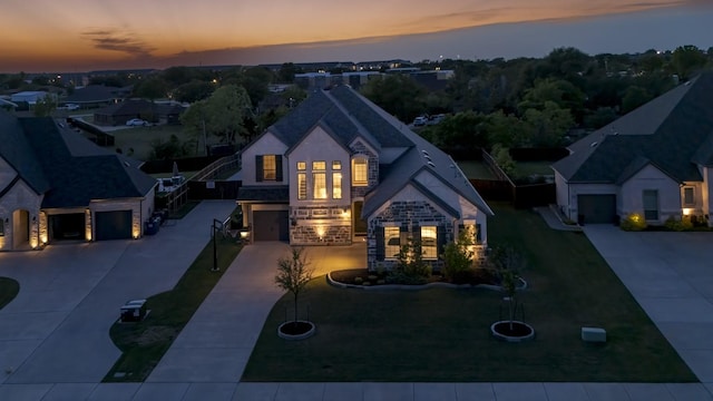 french provincial home with french doors, a garage, concrete driveway, stone siding, and stucco siding