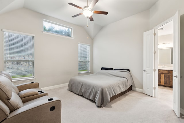 bedroom with vaulted ceiling, light carpet, baseboards, connected bathroom, and ceiling fan