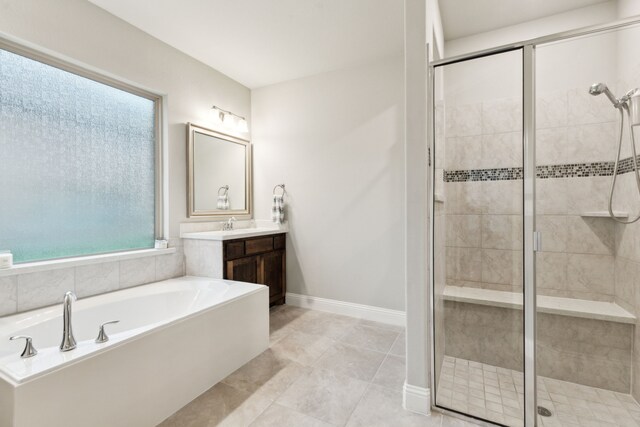bathroom featuring a stall shower, vanity, and a garden tub